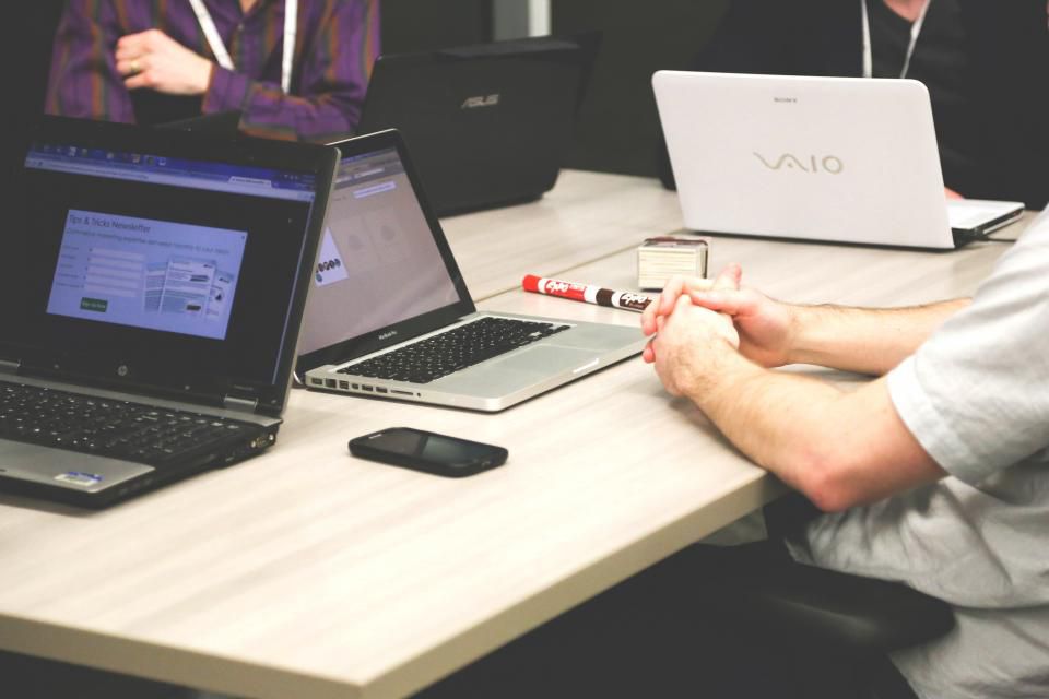 Practice administrators working on laptops in a medical office